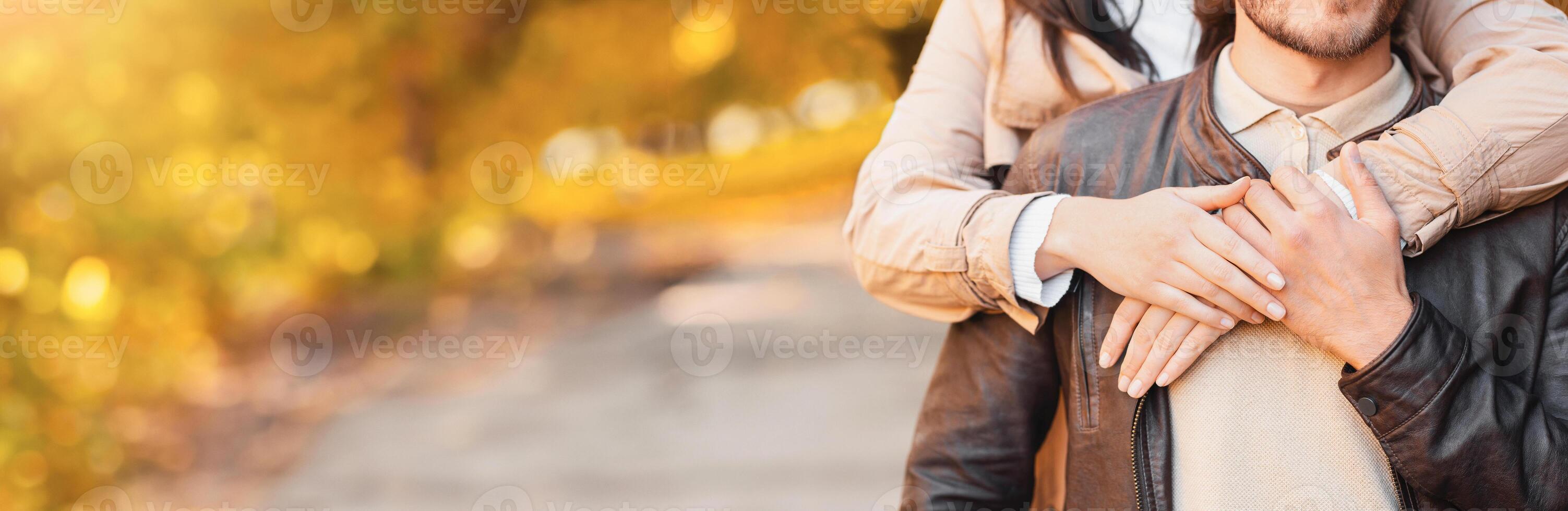 Love, affectionate concept. Girl hands hugging boyfriend from behind, park background, panorama with copy space photo