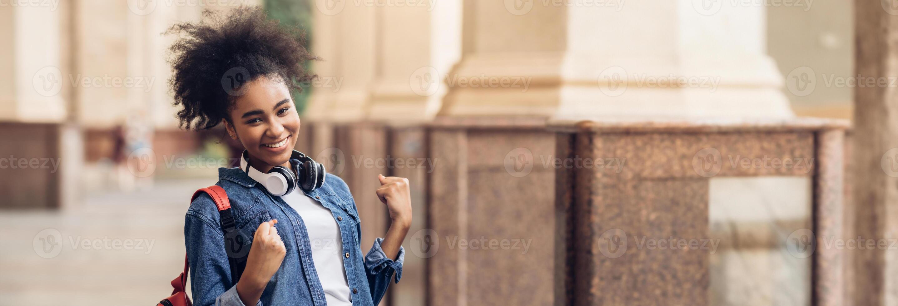 Cheerful African American Student Girl Celebrating Passed Exam Gesturing Yes Smiling To Camera Posing With Backpack Standing Outside Of College Building. I Did It, Educational Success, Copy Space photo