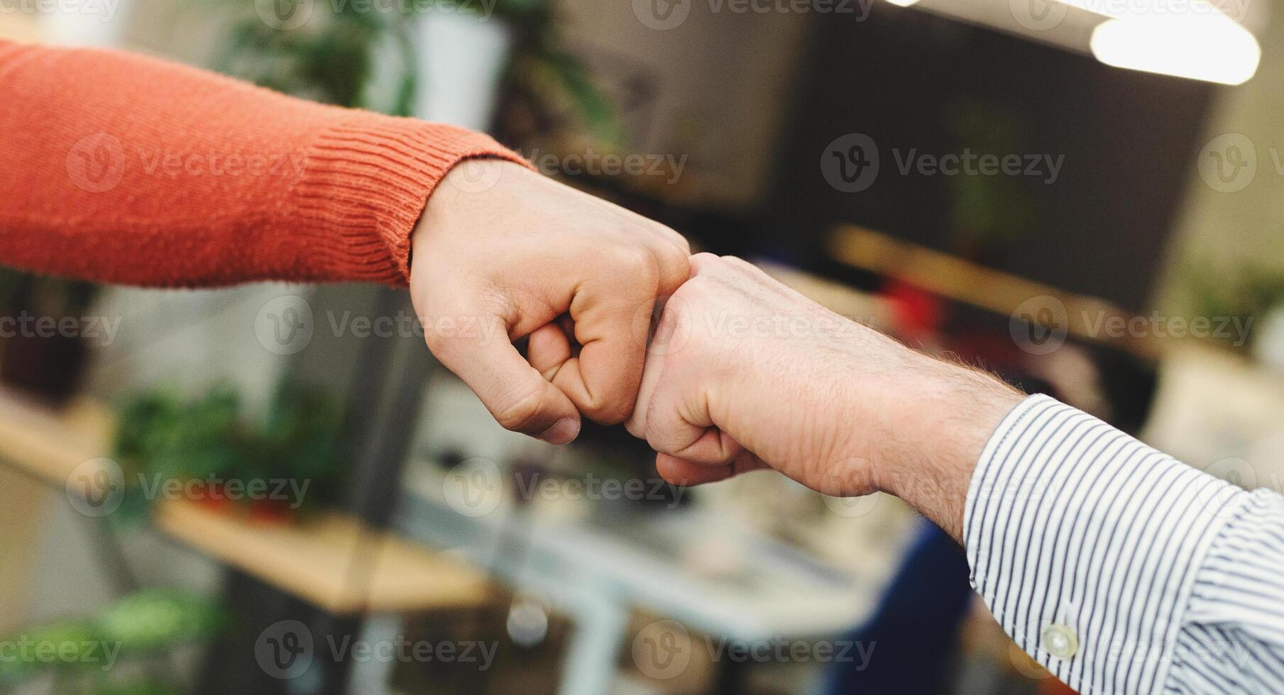 Business partners giving fist bump after complete a deal. Successful teamwork with hands gesture communication. photo
