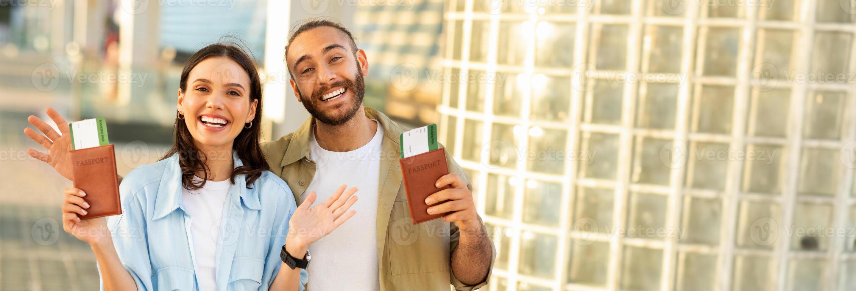 Happy young european guy with beard and woman hold passports and tickets, enjoy trip to station, outdoor. Tourist emotion, active lifestyle, travel at summer, vacation together, copy space photo