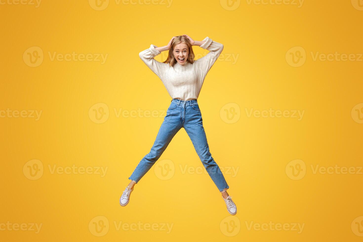 Unbelievable sales. Excited girl jumping in air with hands on head photo