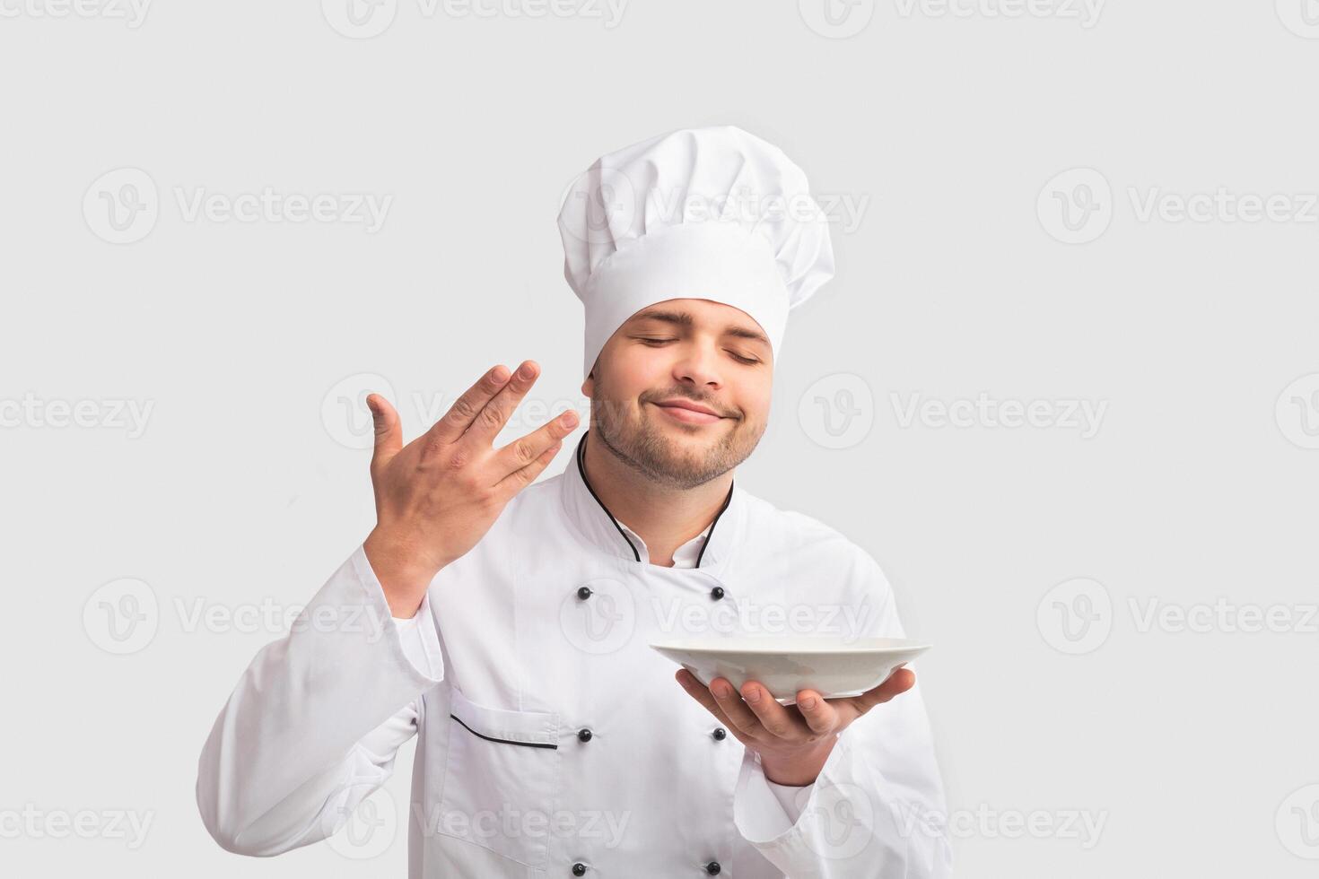 Cooking Food. Chef Man Holding Plate Smelling The Aroma Of Dish Standing Over White Studio Background. Panorama photo