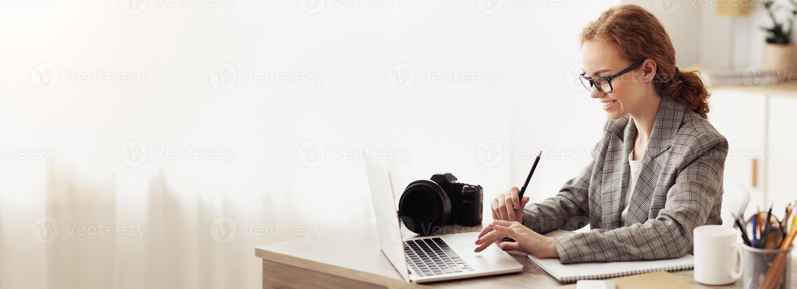 Young reporter transfering image data from camera to laptop, ready to write new article photo