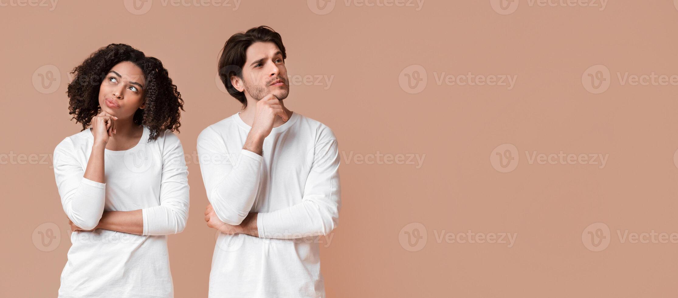 Solution Thinking. Portrait of pensive interracial couple with thoughtful face expression over yellow studio background with empty space photo