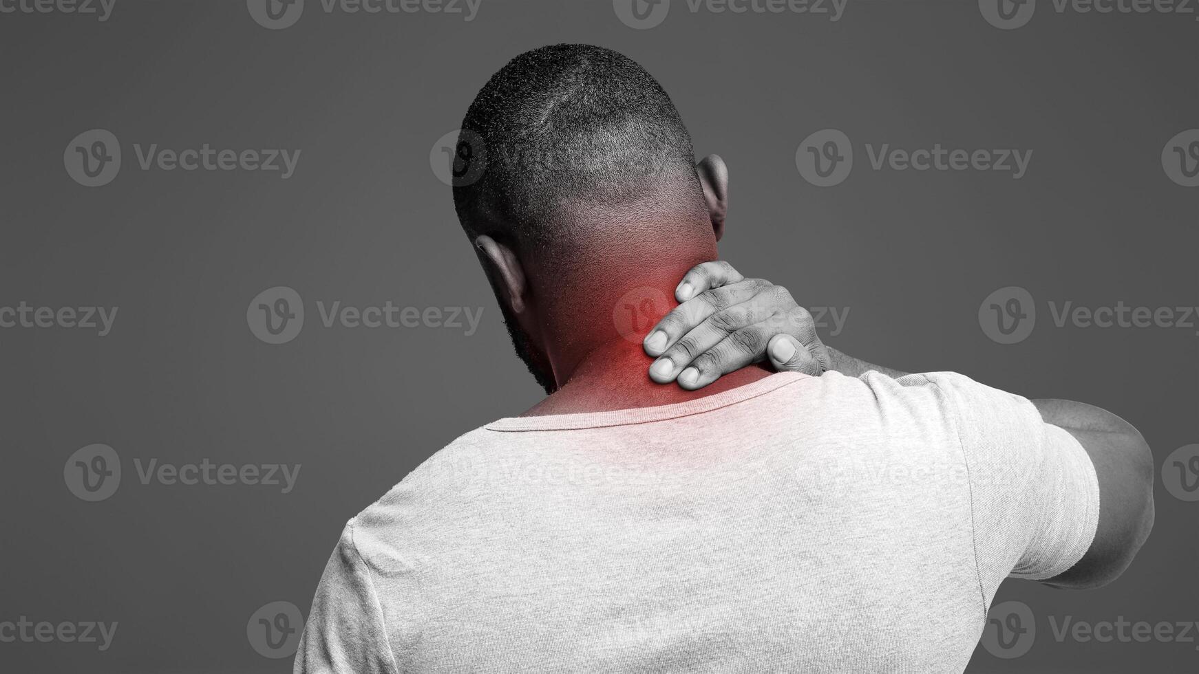 Black guy suffering from pain in neck. Symptom of cervical chondrosis. Inflammation of vertebra, back view photo