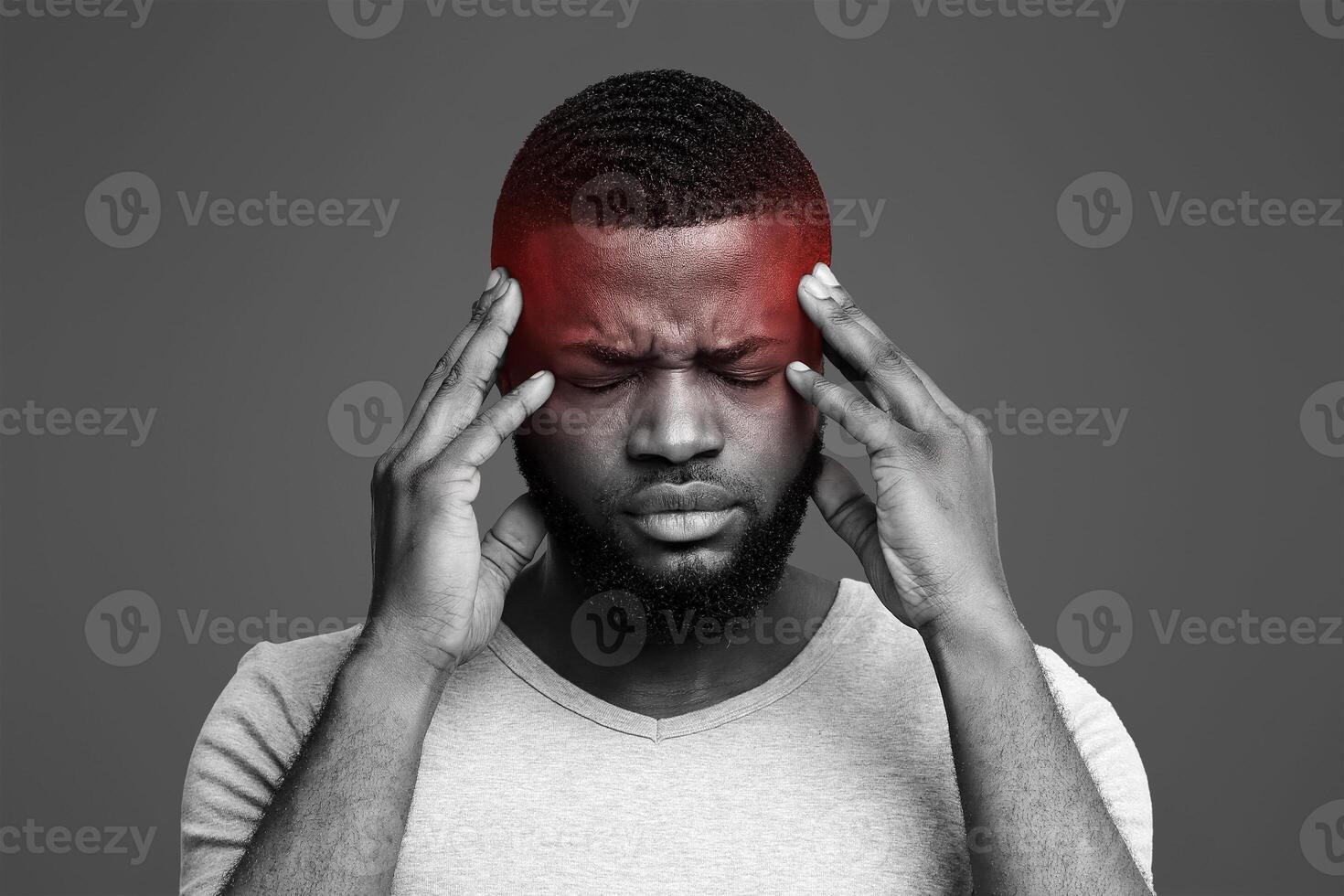 Young afro man having headache, touching his highlighted temples, migraine concept photo