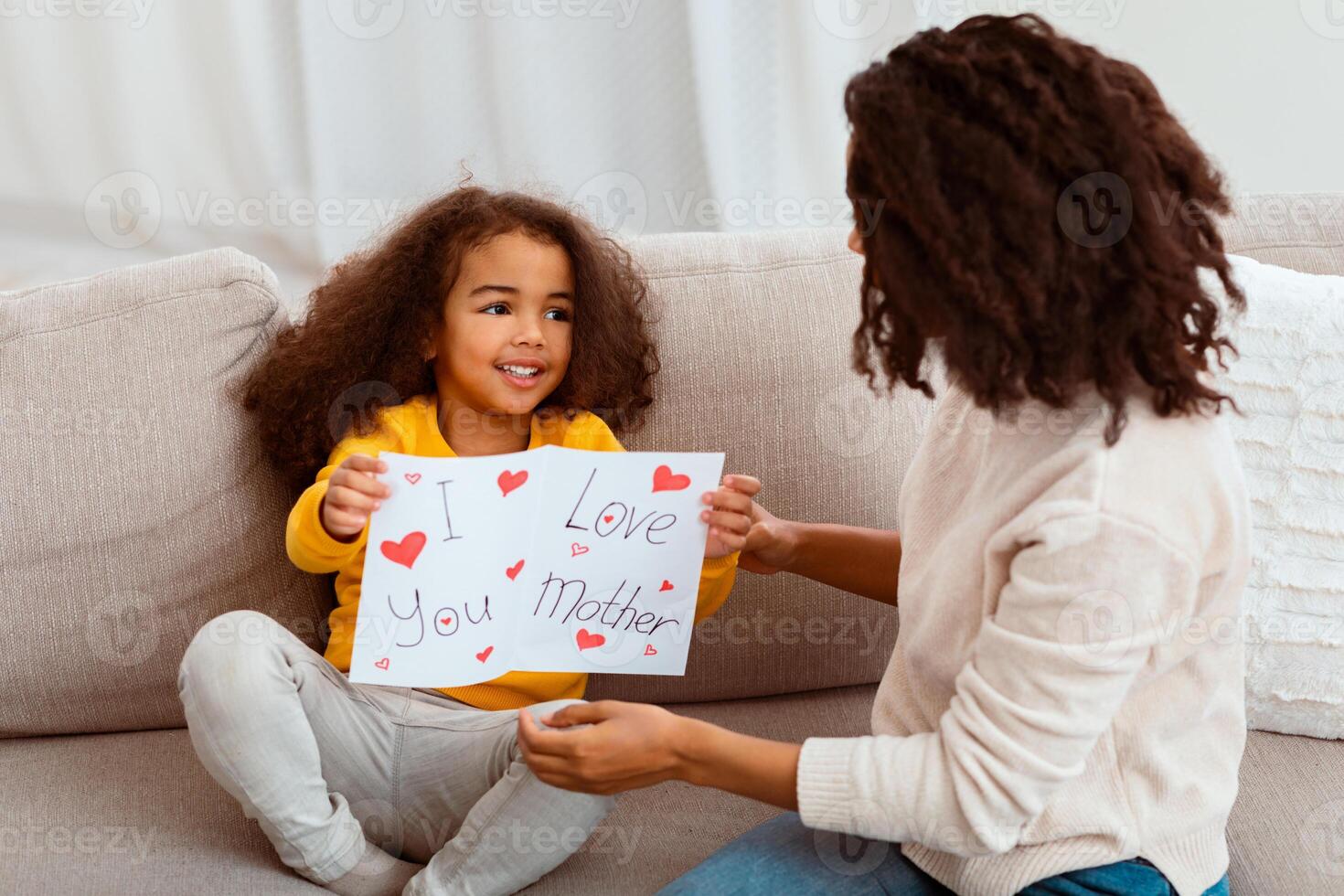 Little African American Daughter Congratulating Mother Giving Self-Made Greeting Card On Holiday At Home. Happy Mother's Day Concept photo