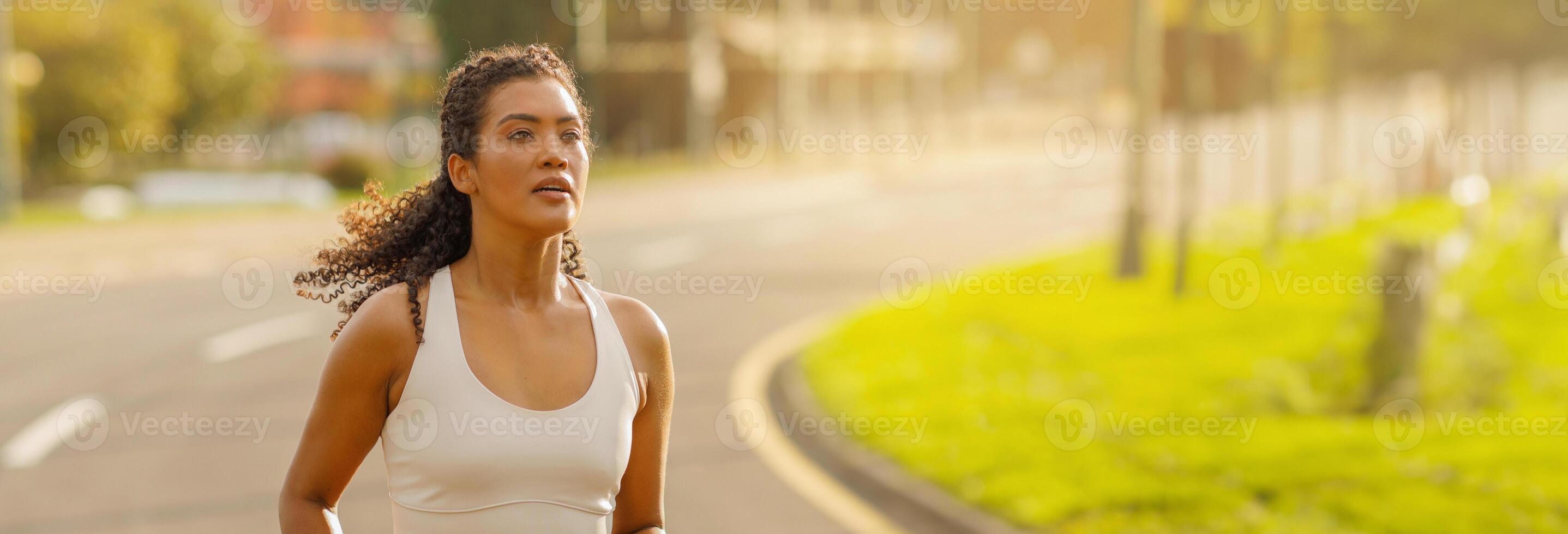 Active young brazilian woman running in park, jogging feeling healthy and motivated in the morning on weekend, wearing sportswear. Wellness and sport motivation concept, copy space photo