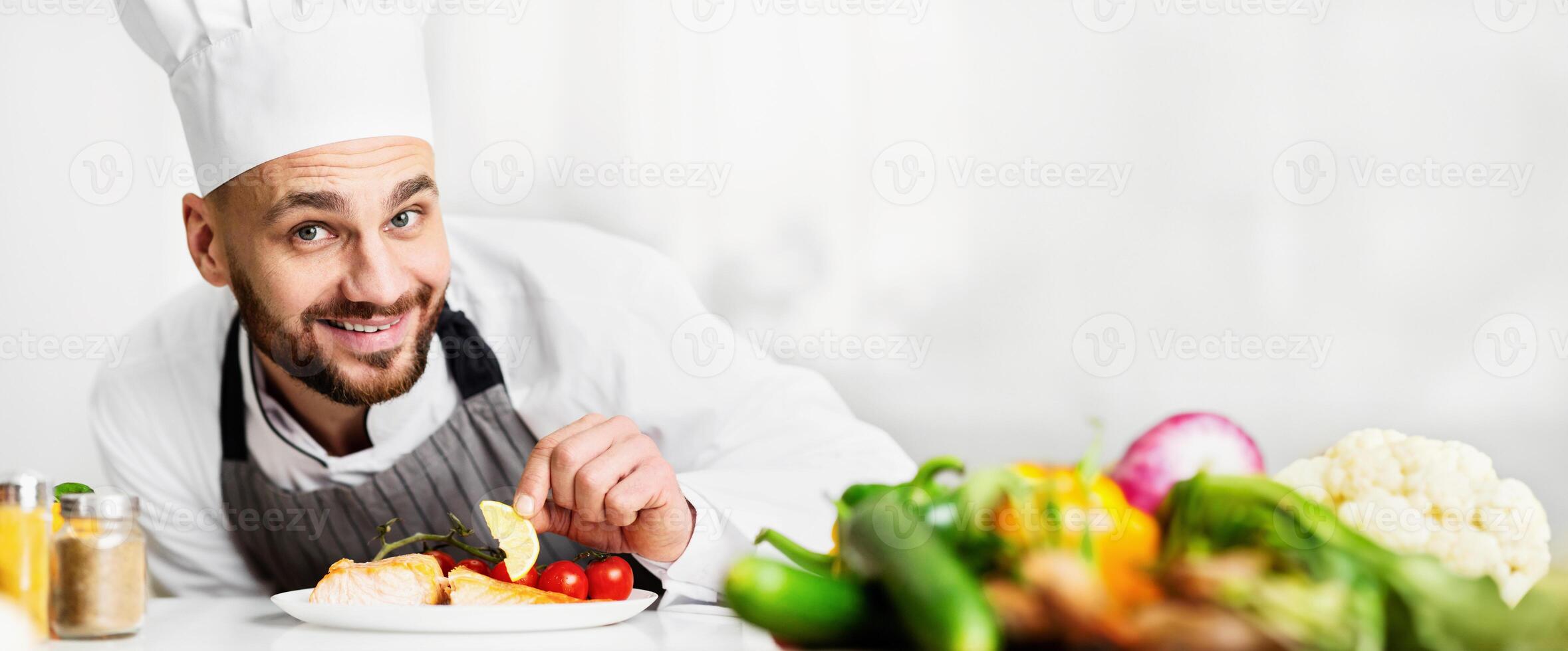 Food Presentation. Happy Cook Man Plating Salmon Steak Preparing Dinner In Restaurant Kitchen. Selective Focus photo