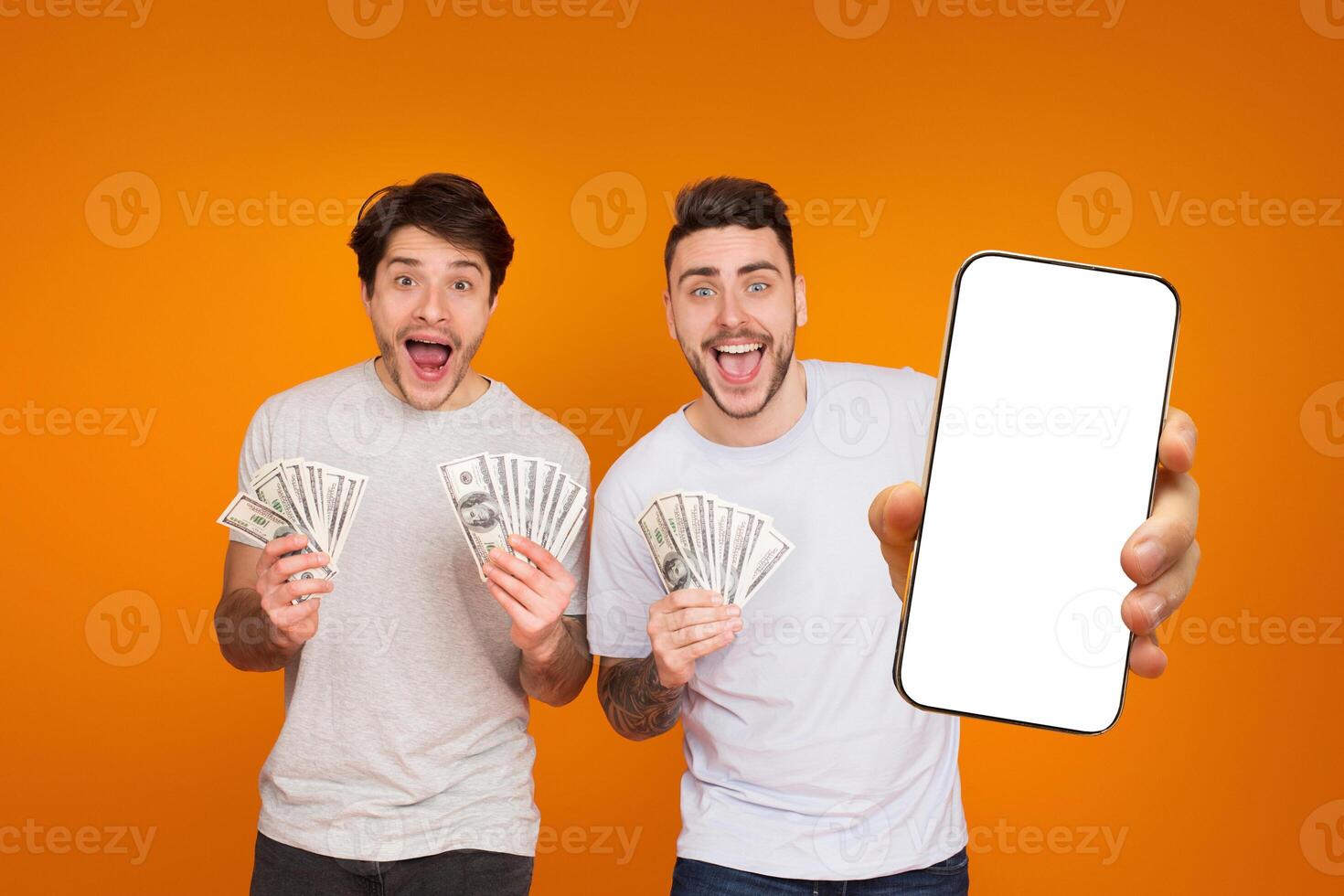 European guys proudly displaying cash and a smartphone, highlighting their financial success and friendship. The blank screen suggests a space for advertising photo