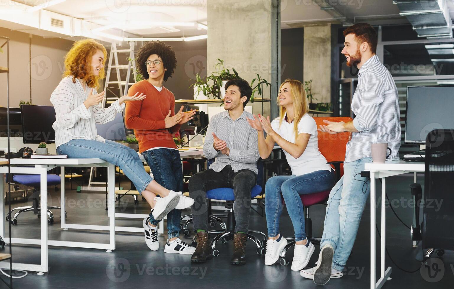 Welcome to team. Cheerful coworkers welcoming new colleague in modern coworking space photo
