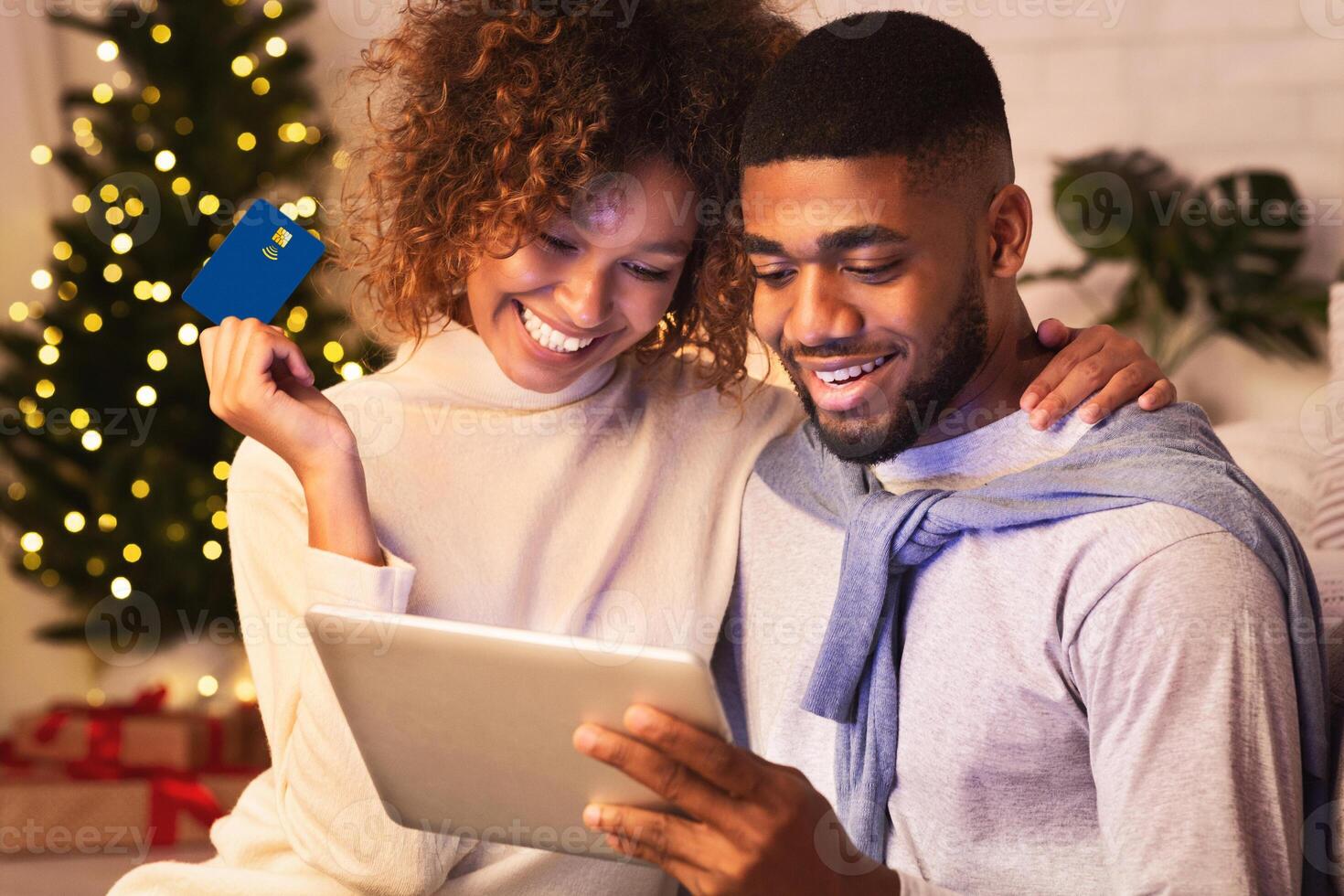 New year online shopping. Happy couple choosing gifts on tablet, enjoying evening at home photo