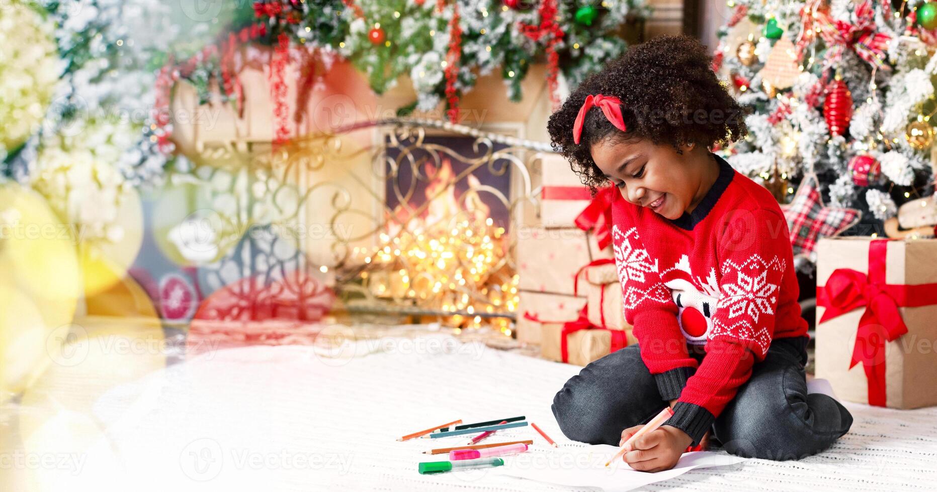 Adorable black little girl sitting on floor and writing letter to Santa Claus, making wish list of presents in decorated room near Christmas tree photo