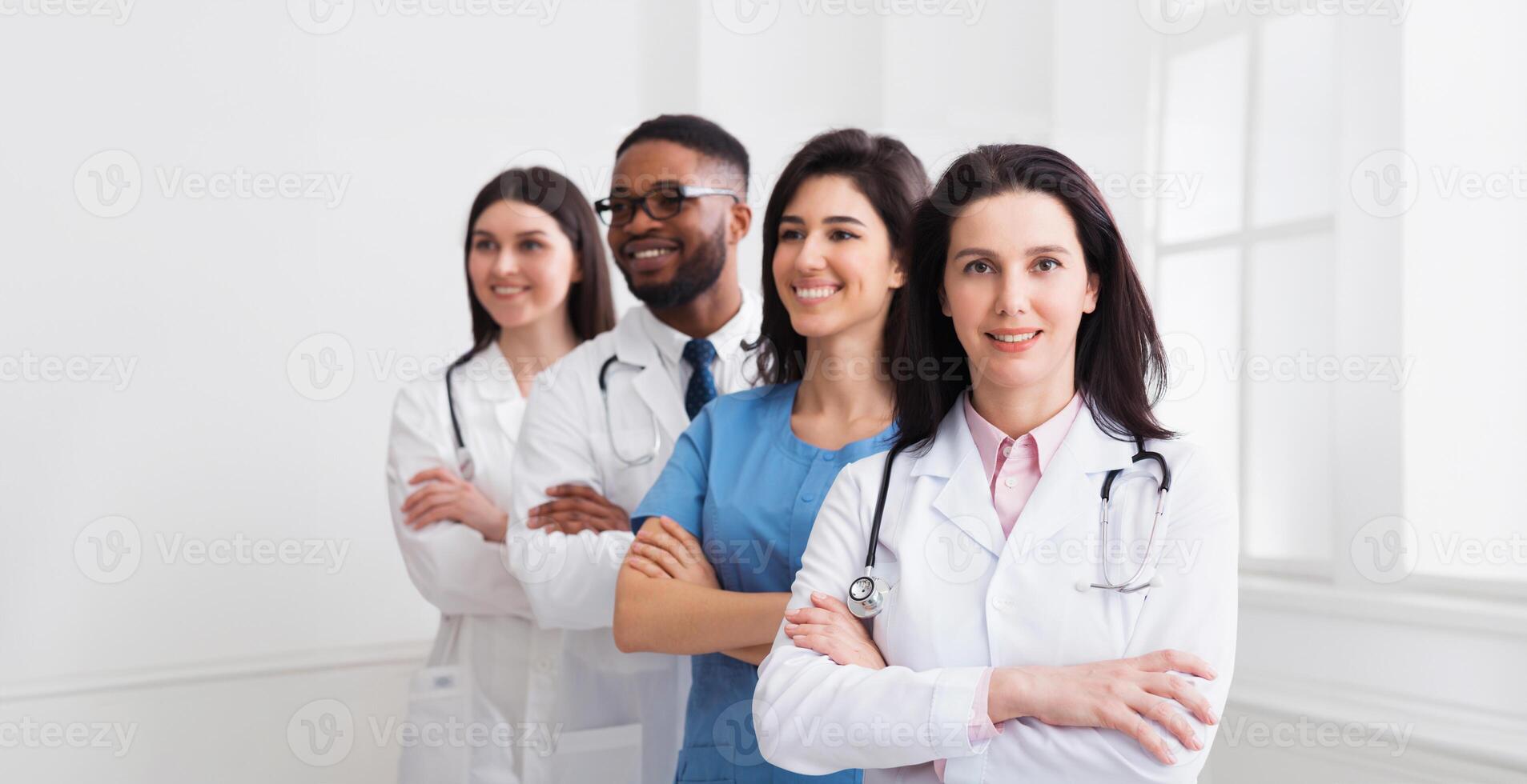 Successful Team Of Medical Interns Standing In Hospital, Headed by Main Doctor photo