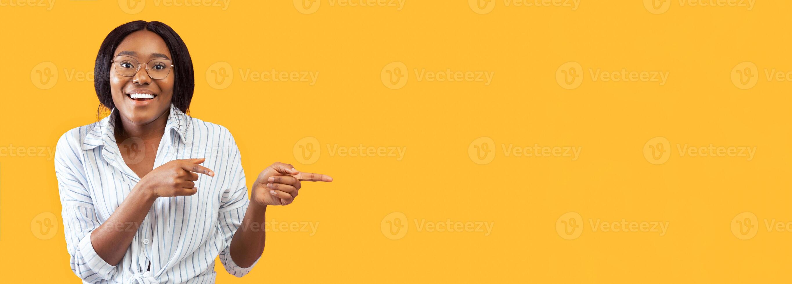 Look There. Smiling Afro Woman Pointing Fingers Aside At Empty Space Standing Over Pink Studio Background. Panorama photo