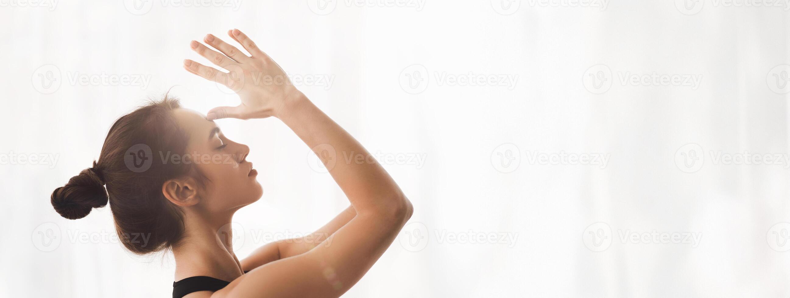 A woman engages in yoga and meditation, promoting mindfulness and relaxation in a calm indoor environment, copy space photo