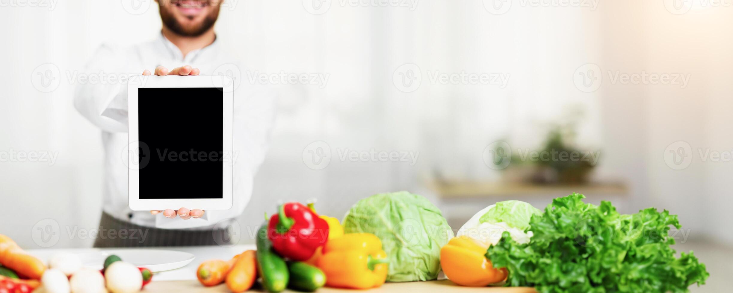 Digital Menu. Chef Man Showing Empty Tablet Computer Screen Cooking Food Standing In Restaurant Kitchen. Cropped, Mockup photo