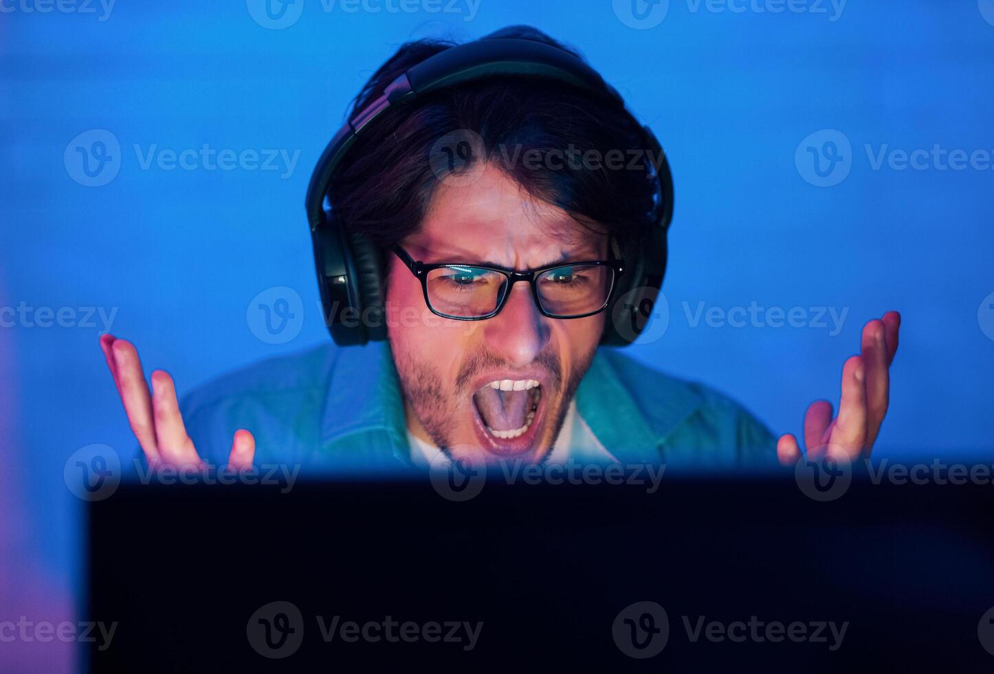 Lost Game. Angry Gamer Young Man Wearing Eyeglasses Or Streamer Playing Online And Shouting, Closeup photo