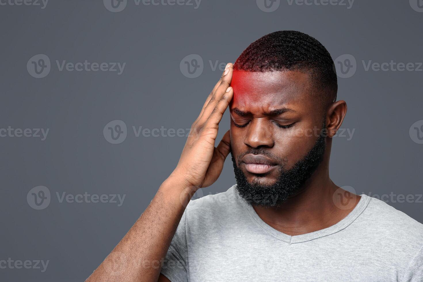Young black man suffering from headache, touching highlighted forehead photo