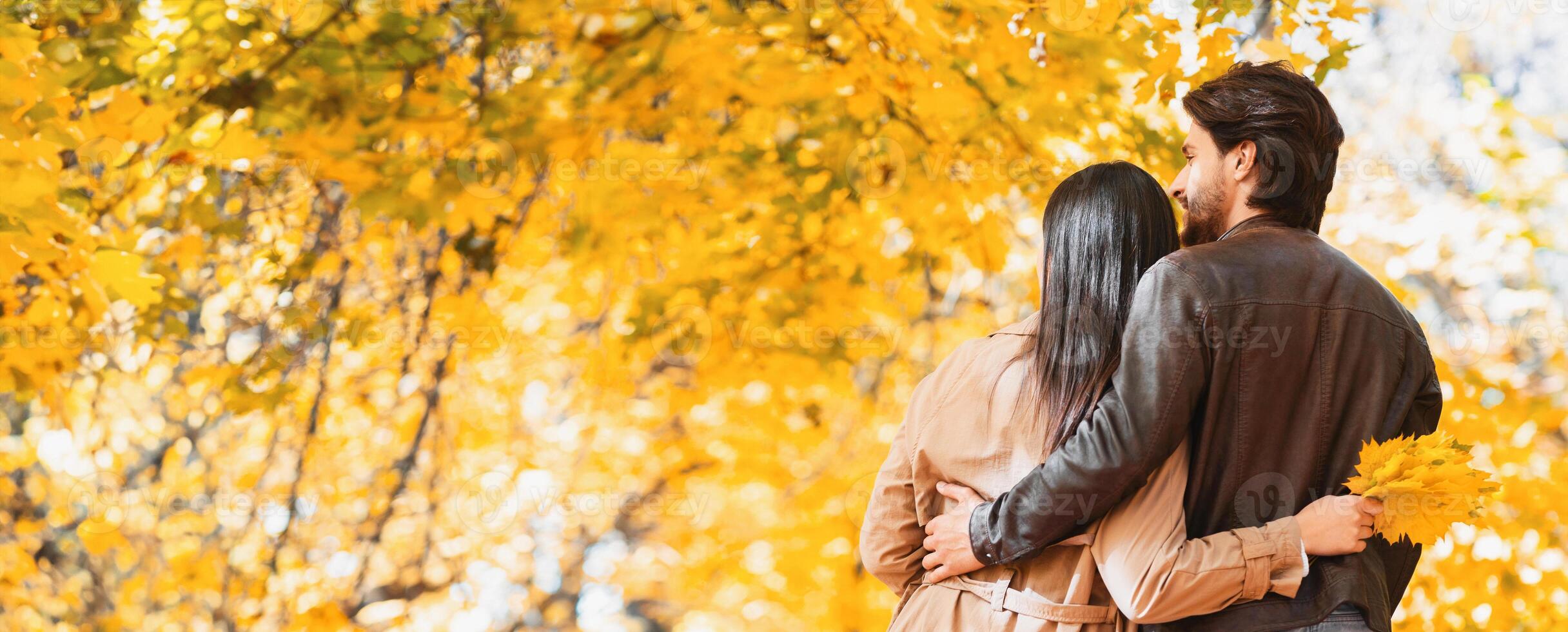 Couple hugging and enjoying together autumn forest beautiful nature, panorama with empty space photo