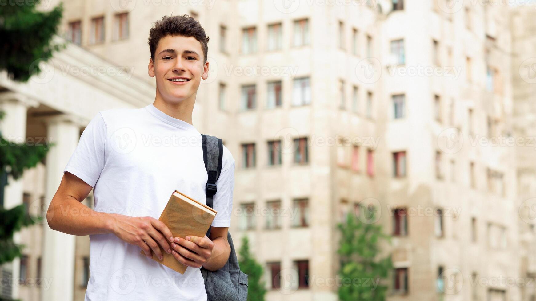 Excited student having break between classes near university, smiling to camera outdoors photo