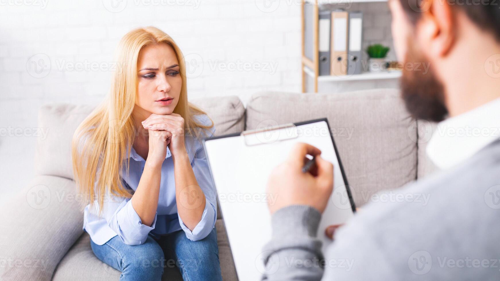 Desperate millennial woman complaining about life problems, specialist taking notes, empty space photo