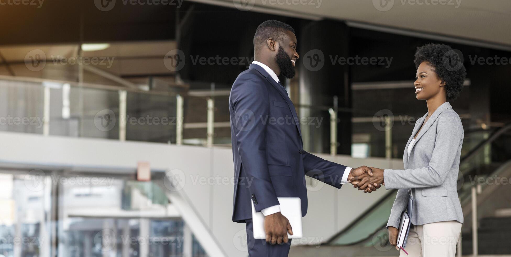 You're hired. African American business people shaking hands near office building after job interview. Side view, copy space photo