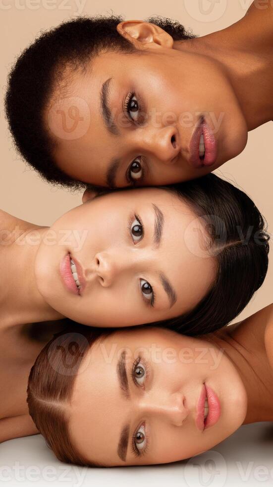 Beauty. Portrait Of Three Multiethnic Models Girls With Perfect Face Skin Posing Over Gray Studio Background. Vertical Panorama photo