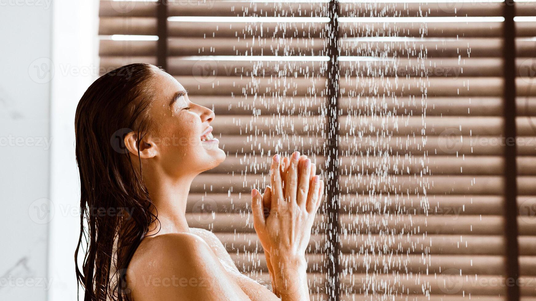 Woman Taking Shower Enjoying Water Splashing On Her, Side View photo