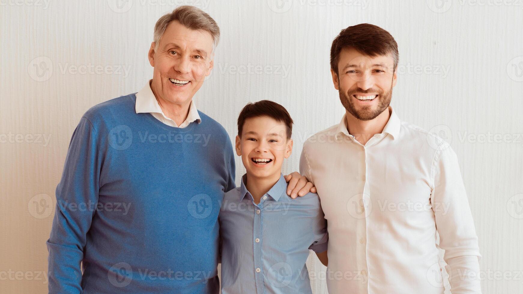Male Family. Boy, Father And Grandfather Hugging Smiling At Camera Posing Over White Wall Indoor. Panorama photo