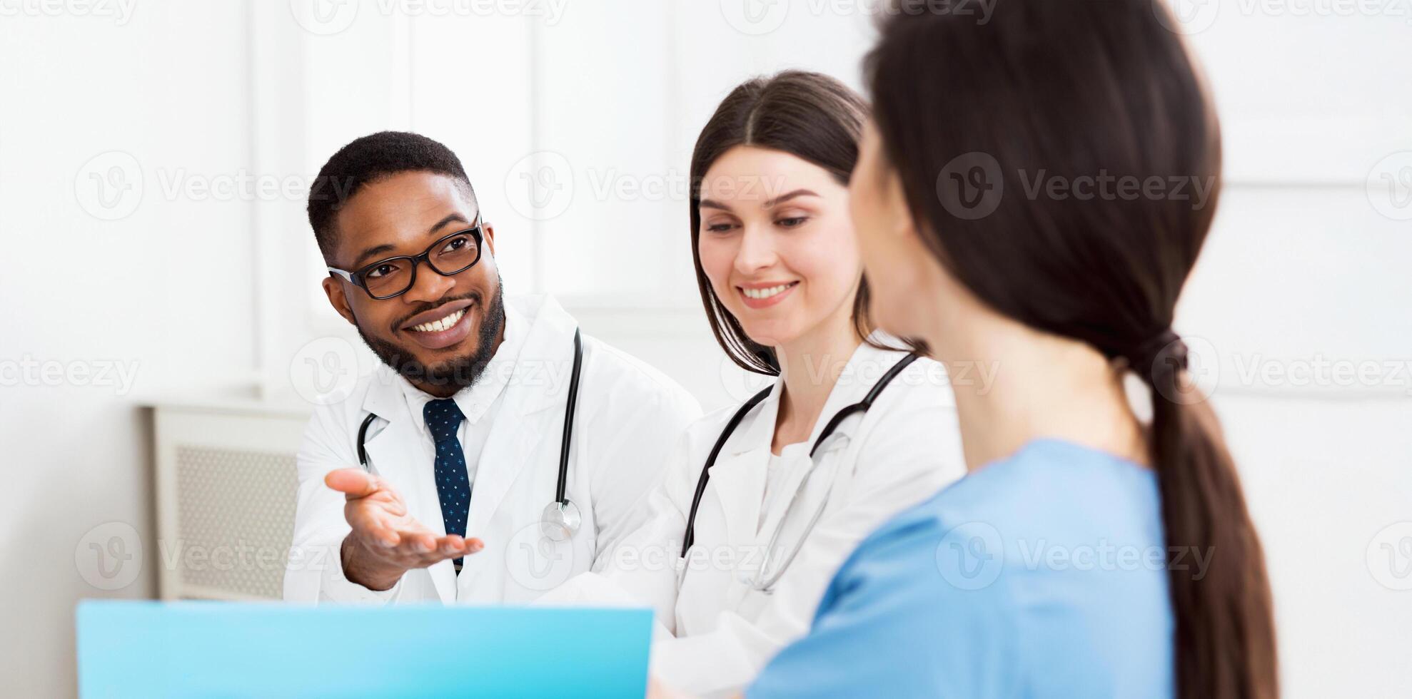 Multiracial medical team having meeting with doctor, discussing patients records photo