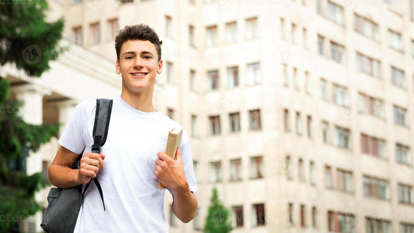 Education concept. Student guy walking near university, waiting for classes, free space photo