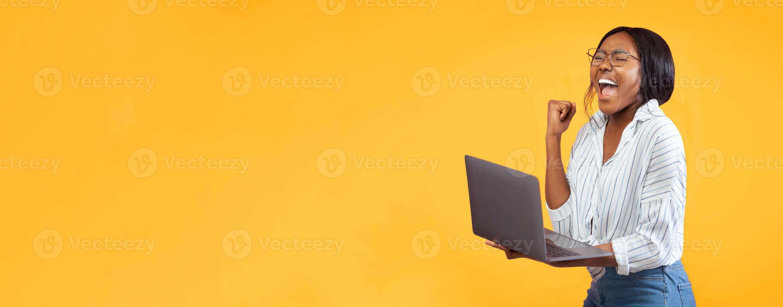 Happy African American Girl Holding Laptop Gesturing Yes Standing Over Pink Studio Background. Panorama, Copy Space photo