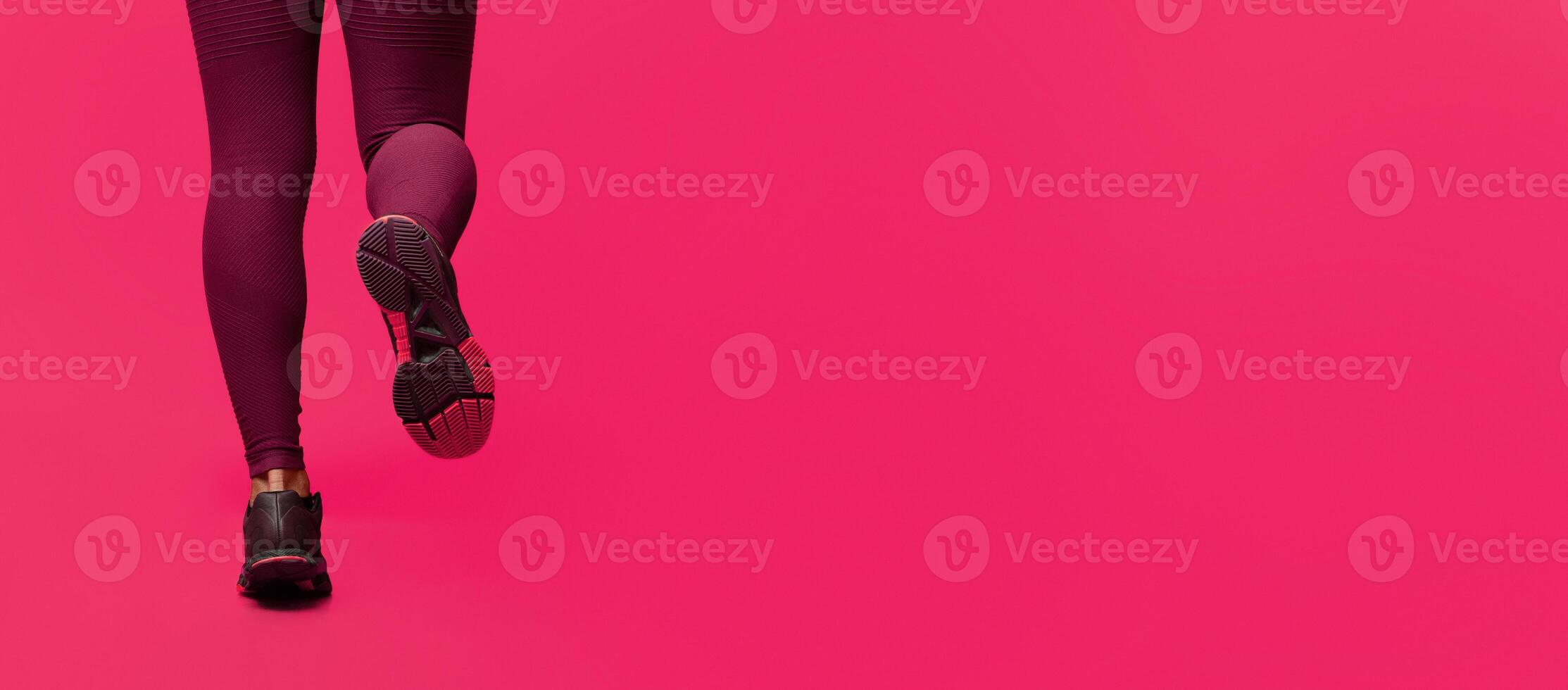 Cropped of black woman runner legs while jogging over red background, empty space photo