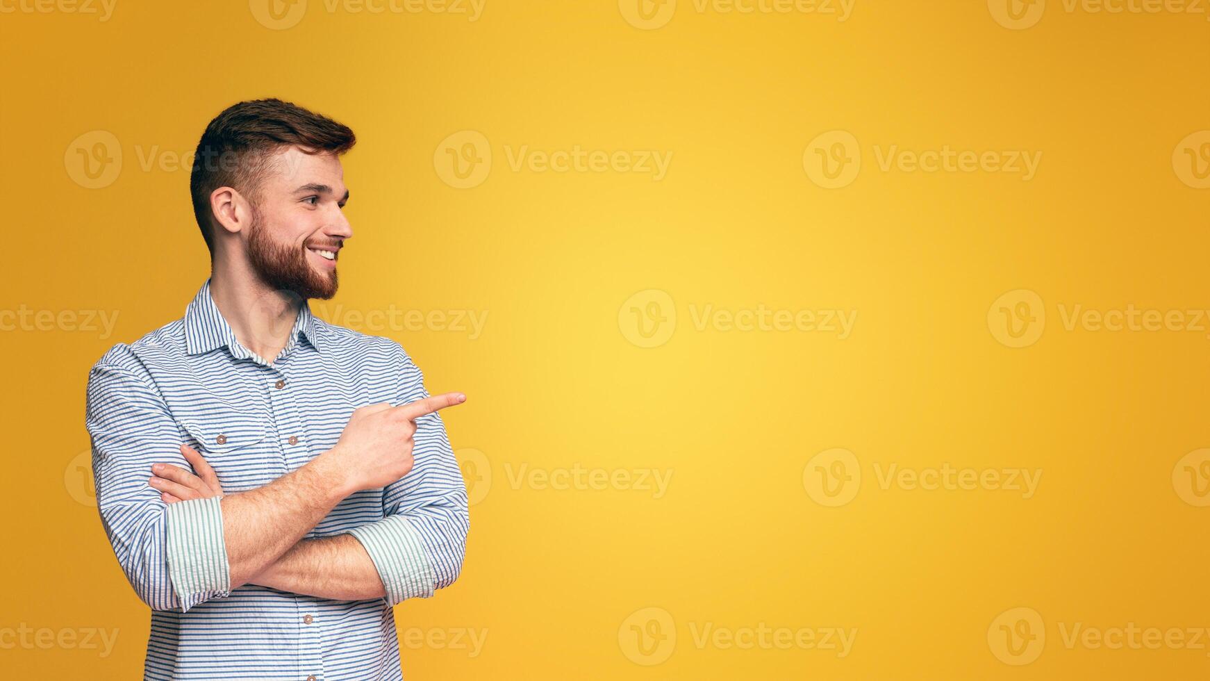 A man with a beard points at something, indicating a direction or highlighting a specific item, panorama with copy space photo