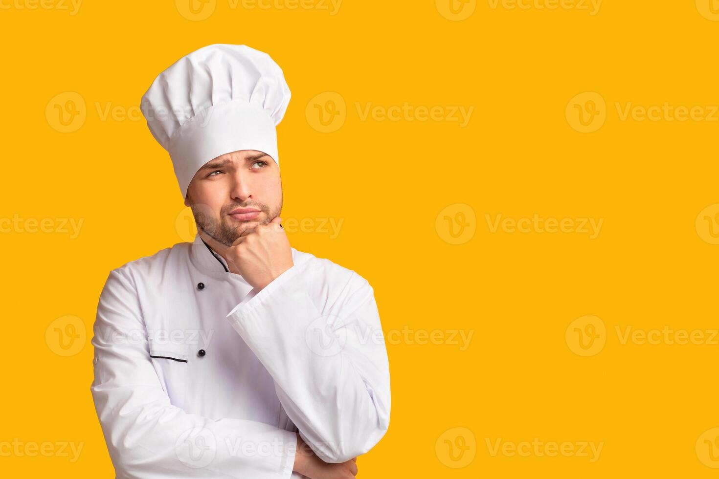 Pensive Chef Man Thinking About New Recipe Touching Chin Standing Over Yellow Studio Background. Panorama photo