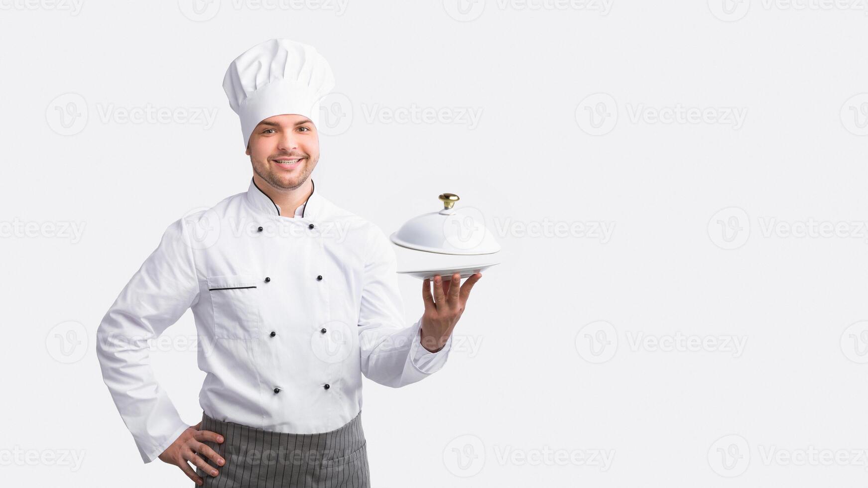 Chef Man Posing With Plate Smiling To Camera Standing Over White Background. Studio Shot photo