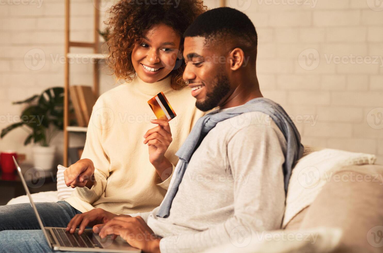 Happy spouses shopping online on laptop, ordering new clothes at home photo