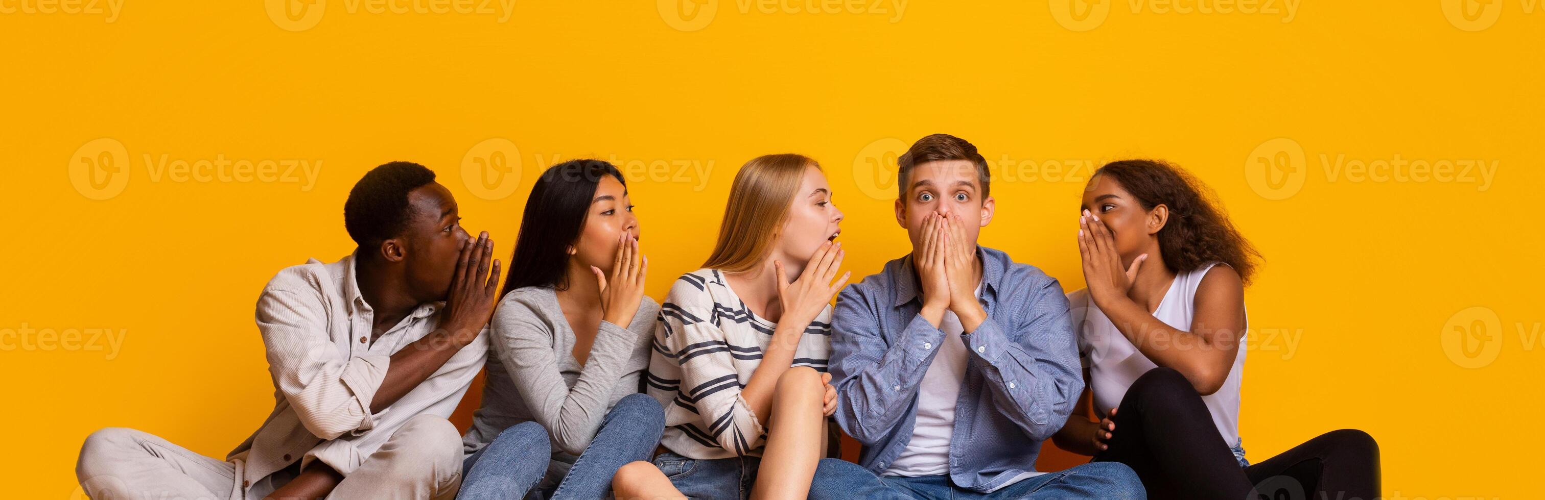 International group of students gossiping over yellow studio background, student lifestyle photo