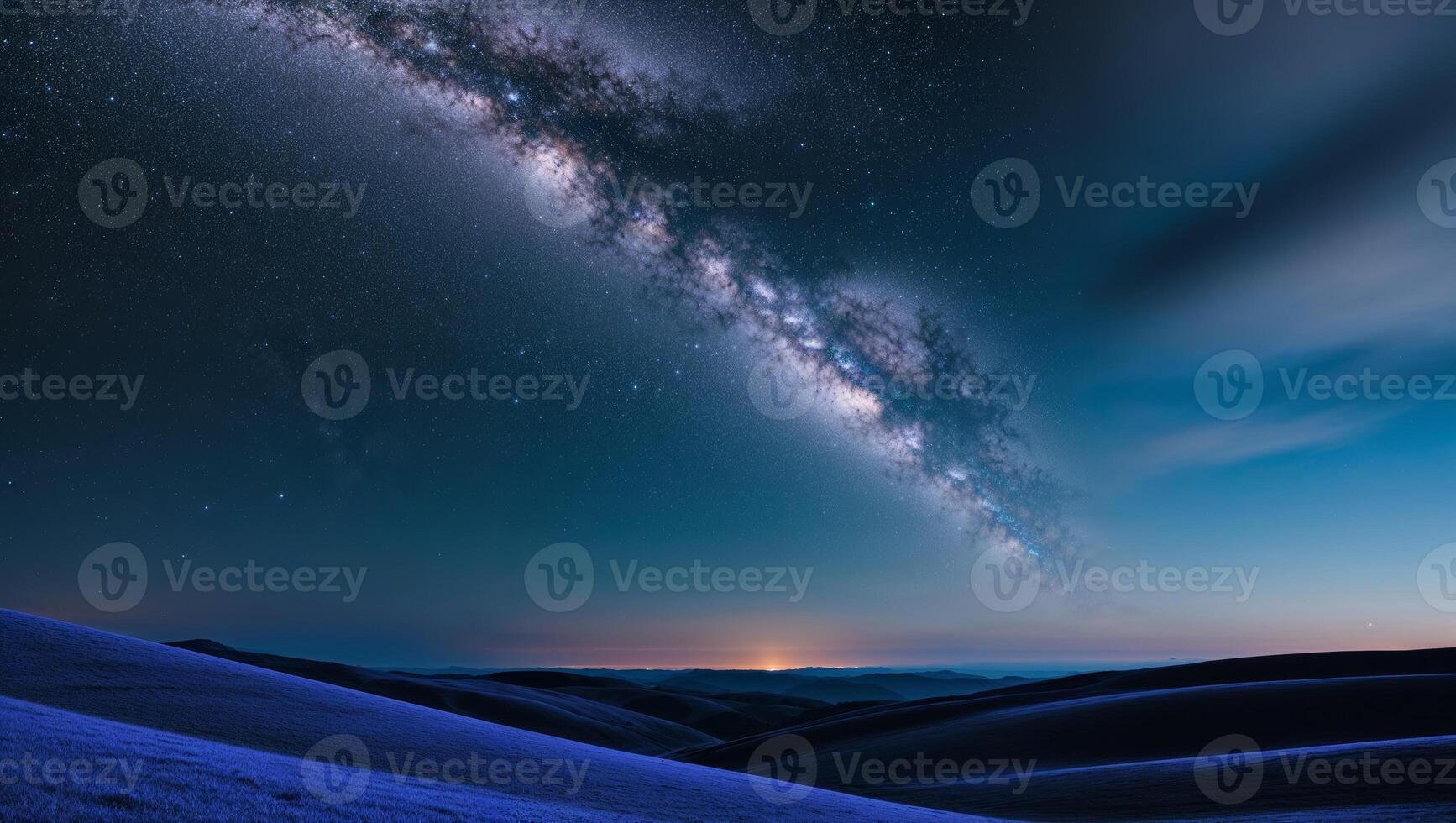 The milky way over the mountains in the night sky photo