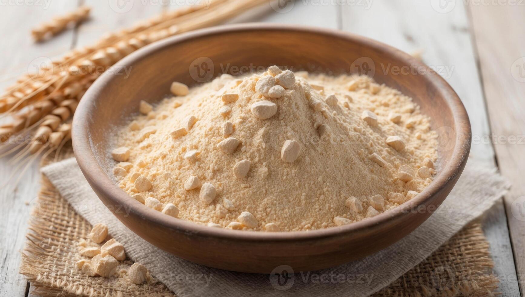 Wheat flour in a wooden bowl on a wooden table photo