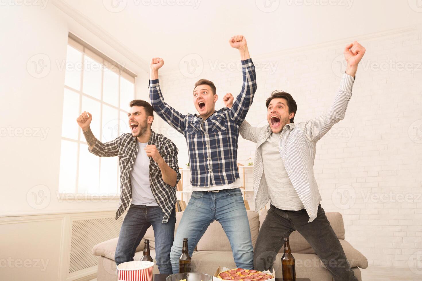 Wow, goal. Guys watching match and celebrating victory, having rest at home photo