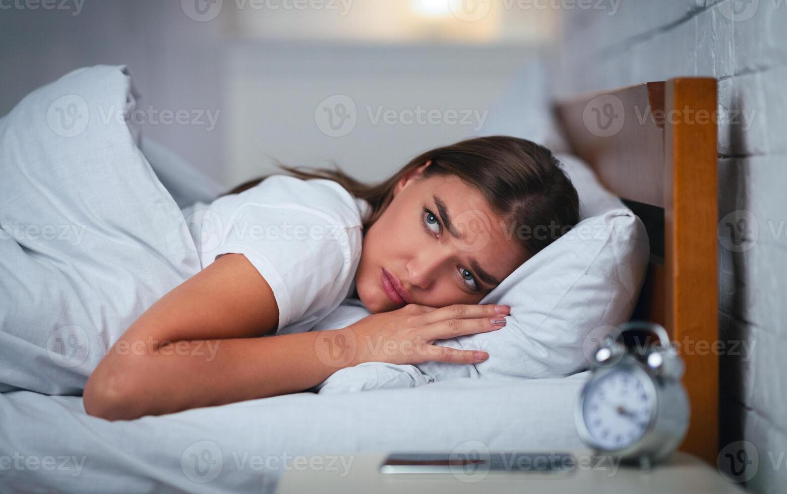 Insomnia. Unhappy Young Woman Suffering From Anxiety And Sleeplessness Lying In Bed At Home At Night. Selecive Focus photo