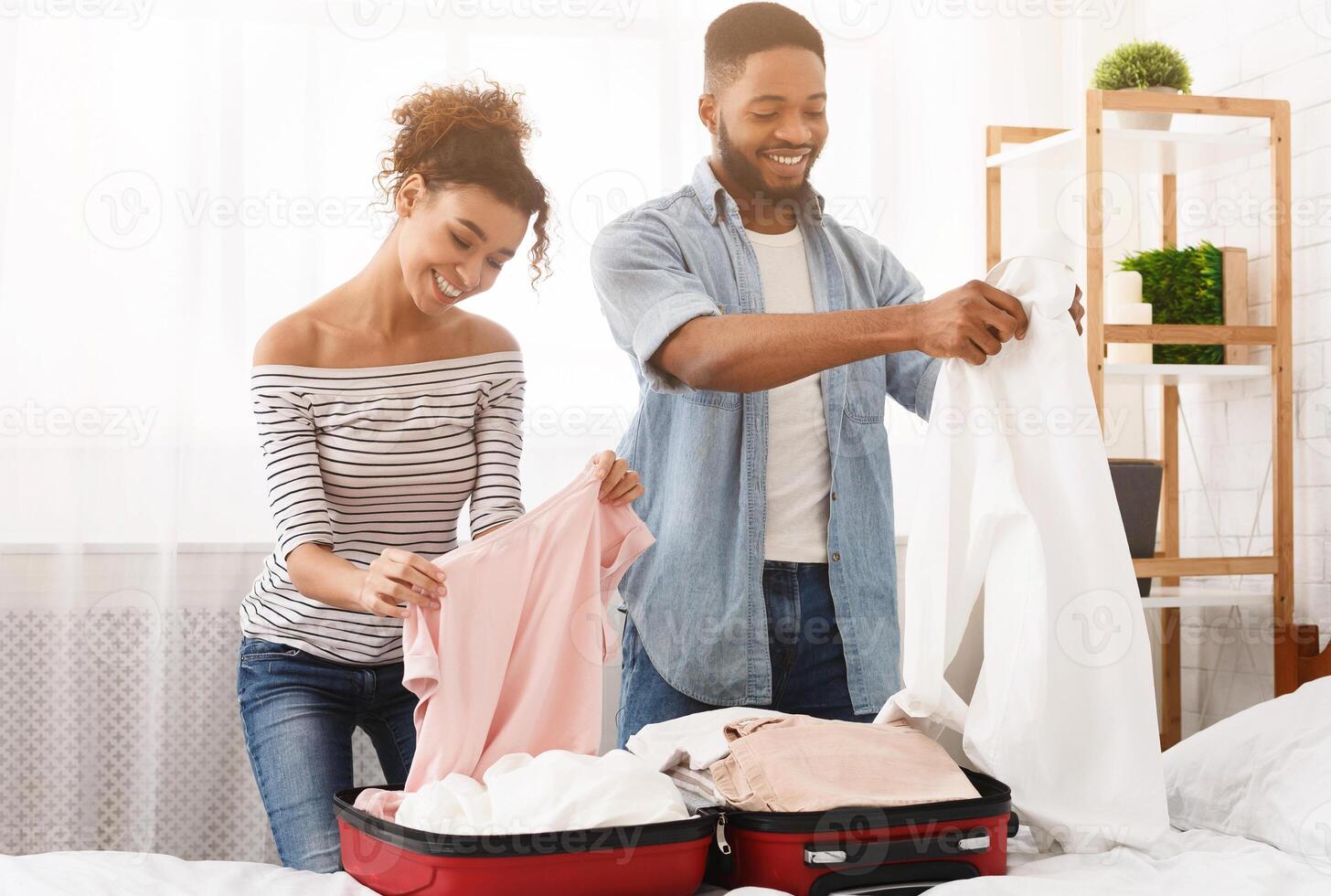 Packing suitcase. Happy couple preparing for travel, folding clothes photo