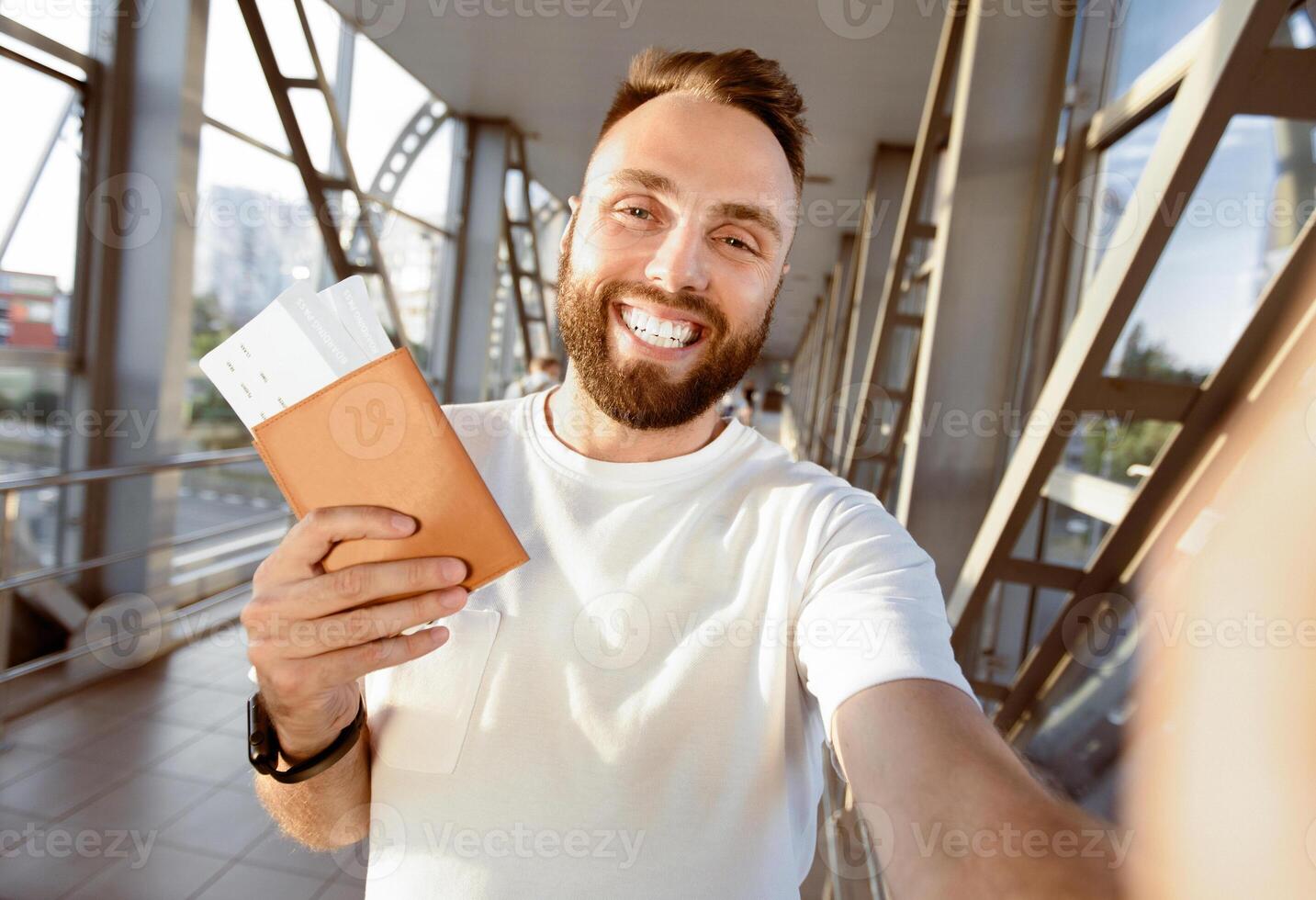 Enjoy Traveling Concept. Hanndsome bearded man taking selfie in airport, waiting for boarding photo