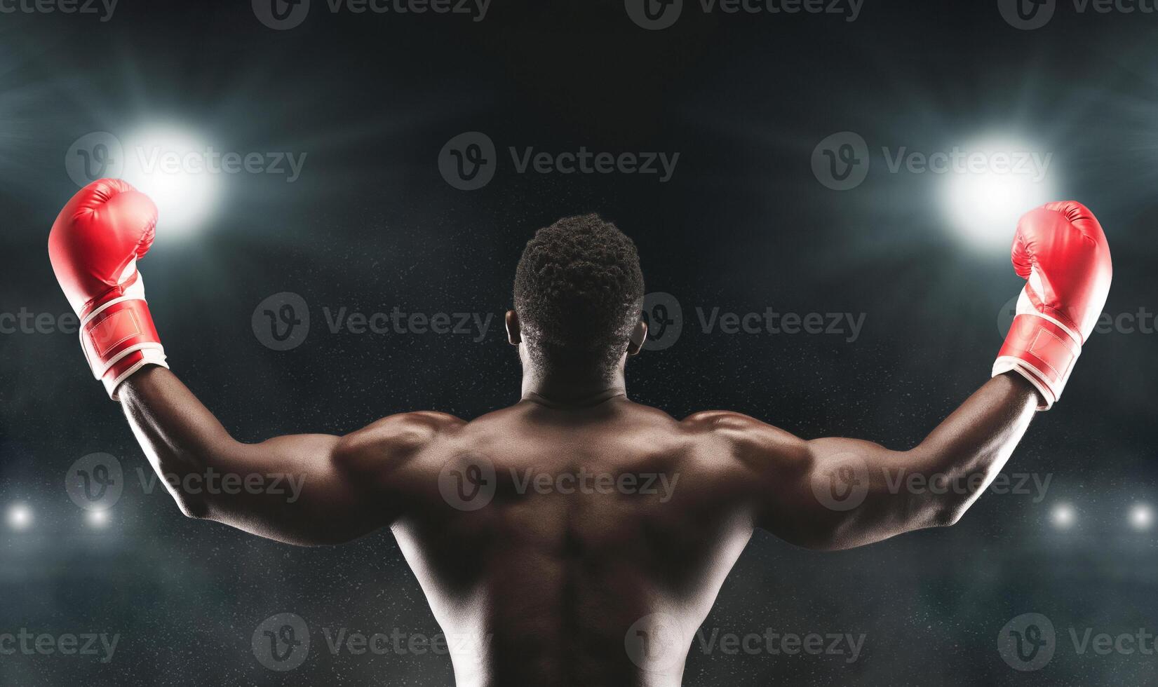 A victorious boxer raises his arms in triumph after a successful match, showcasing his muscular physique and determination. photo