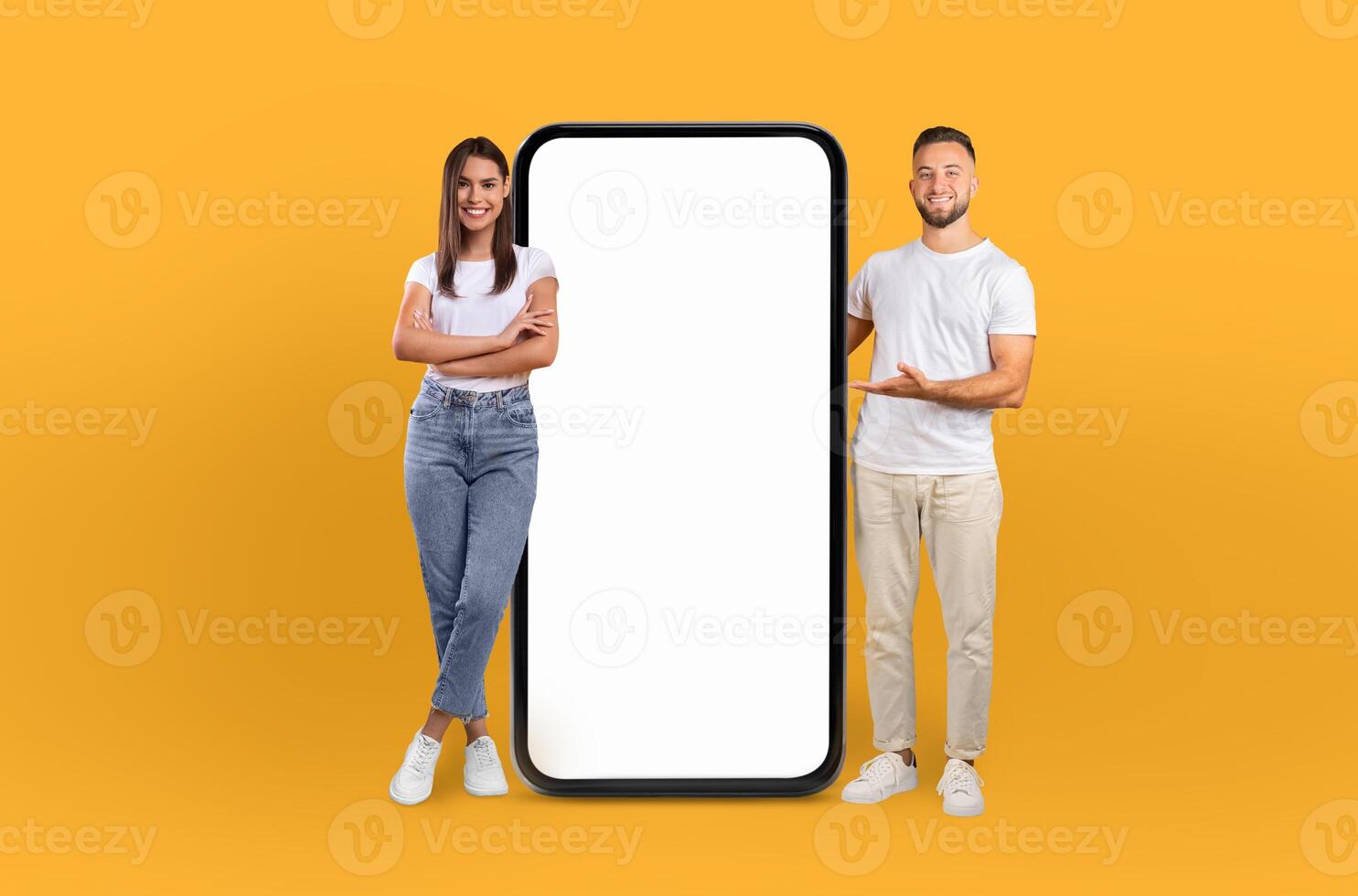 The young man and woman confidently stand by a smartphone with a blank screen, signaling a tech-savvy generation. photo