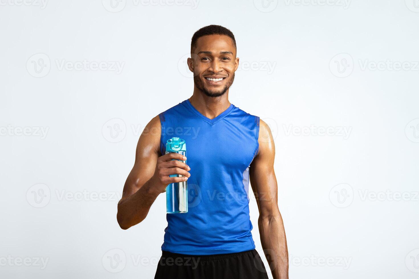 Portrait Of Athletic Black Man Holding Bottle Of Refreshing Water, Resting After Workout, Thirsty Male With A Drink photo
