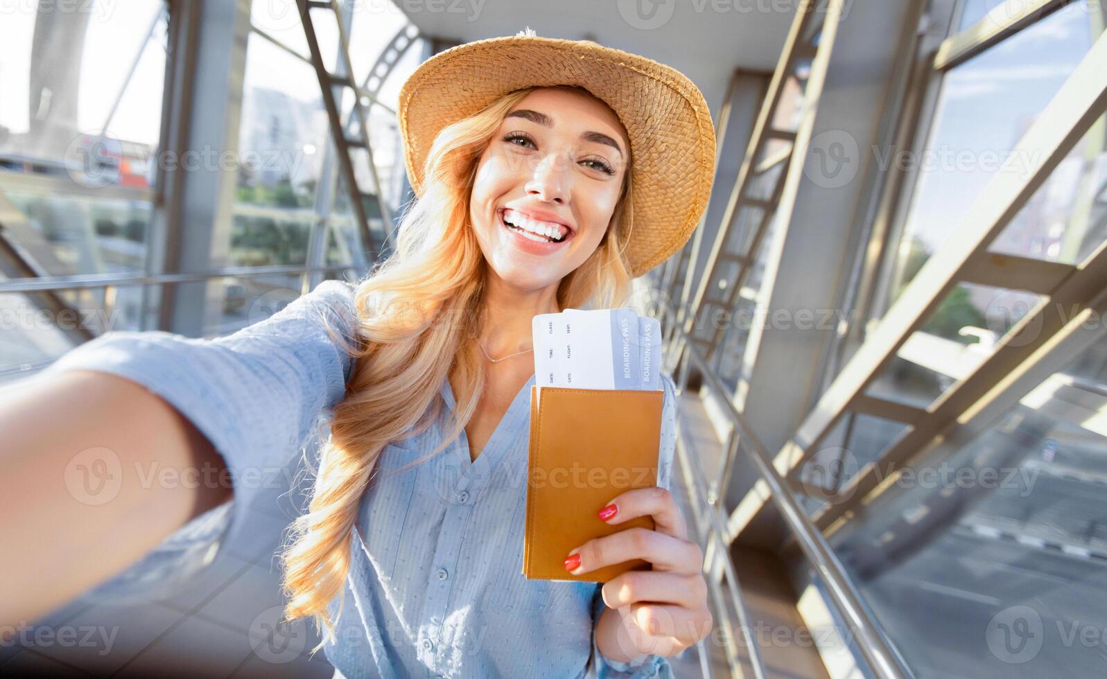 Enjoy traveling. Beautiful woman taking selfie in airport, waiting for boarding photo