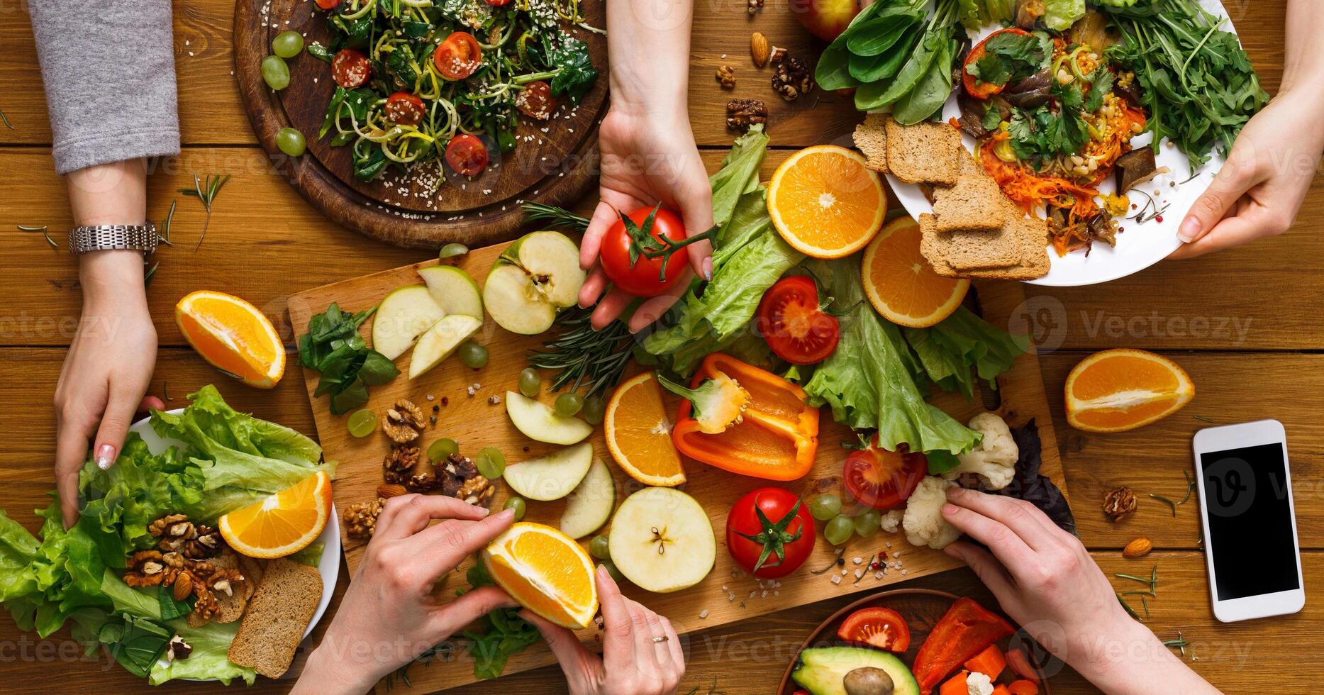 Healthy vegetarian dinner table. Women at home together, eating fruits and vegetables, top view, flat lay, crop photo